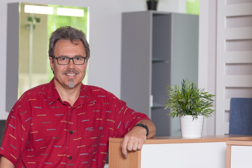 Inhaber Ralf Warnecke lehnt am Tresen in seinem Büro