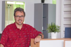 Inhaber Ralf Warnecke lehnt am Tresen in seinem Büro