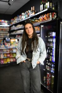 Die Inhaberin des Kiosks steht in Ihrem Geschäft