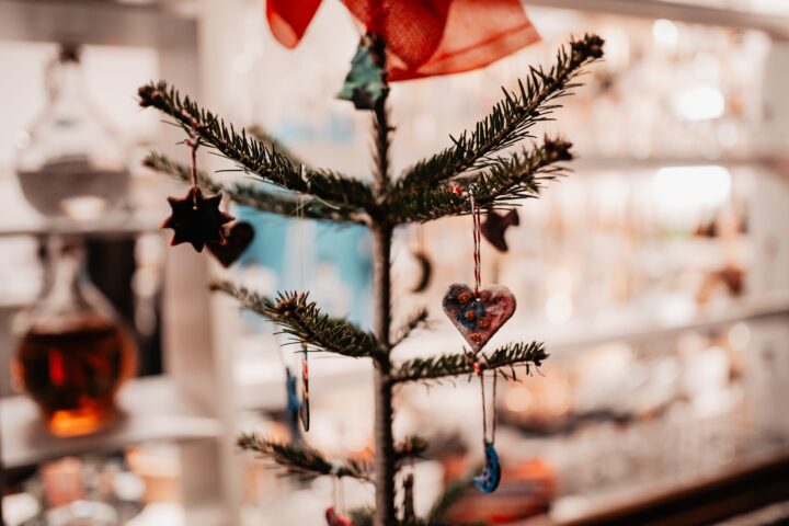 Geschmückter Tannenbaum vor einem beleuchteten Geschäft