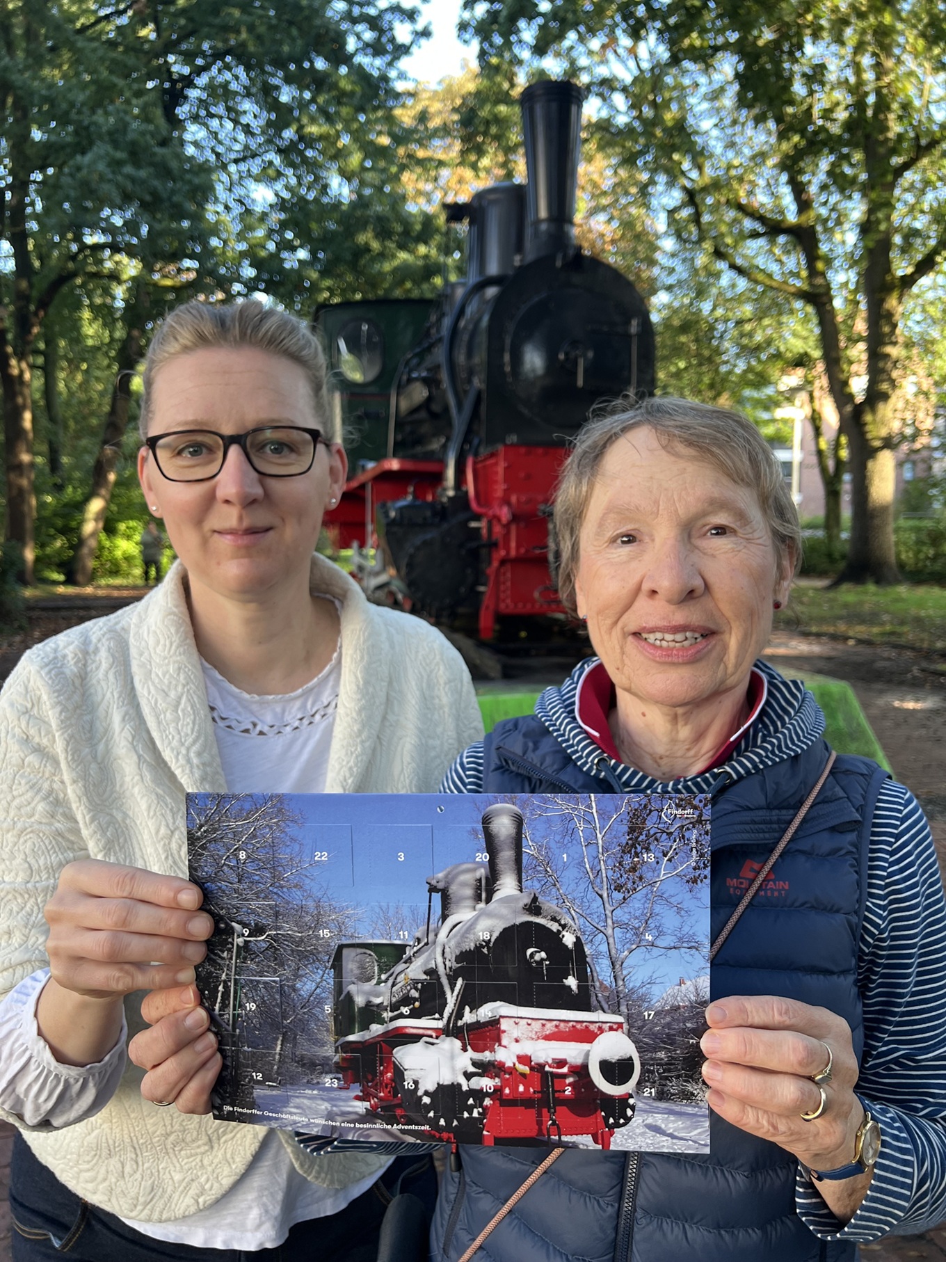 Katrin Grosch, Vorsitzende des Findorffer Geschäftsleute e. V. und die Gewinnerin des Foto-Wettbewerbs, Helga Brüning, präsentieren den Findorffer Adventskalender 2026
