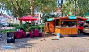 Der Bratwurststand mit einer überdachten Sitzecke auf einem Straßenfest