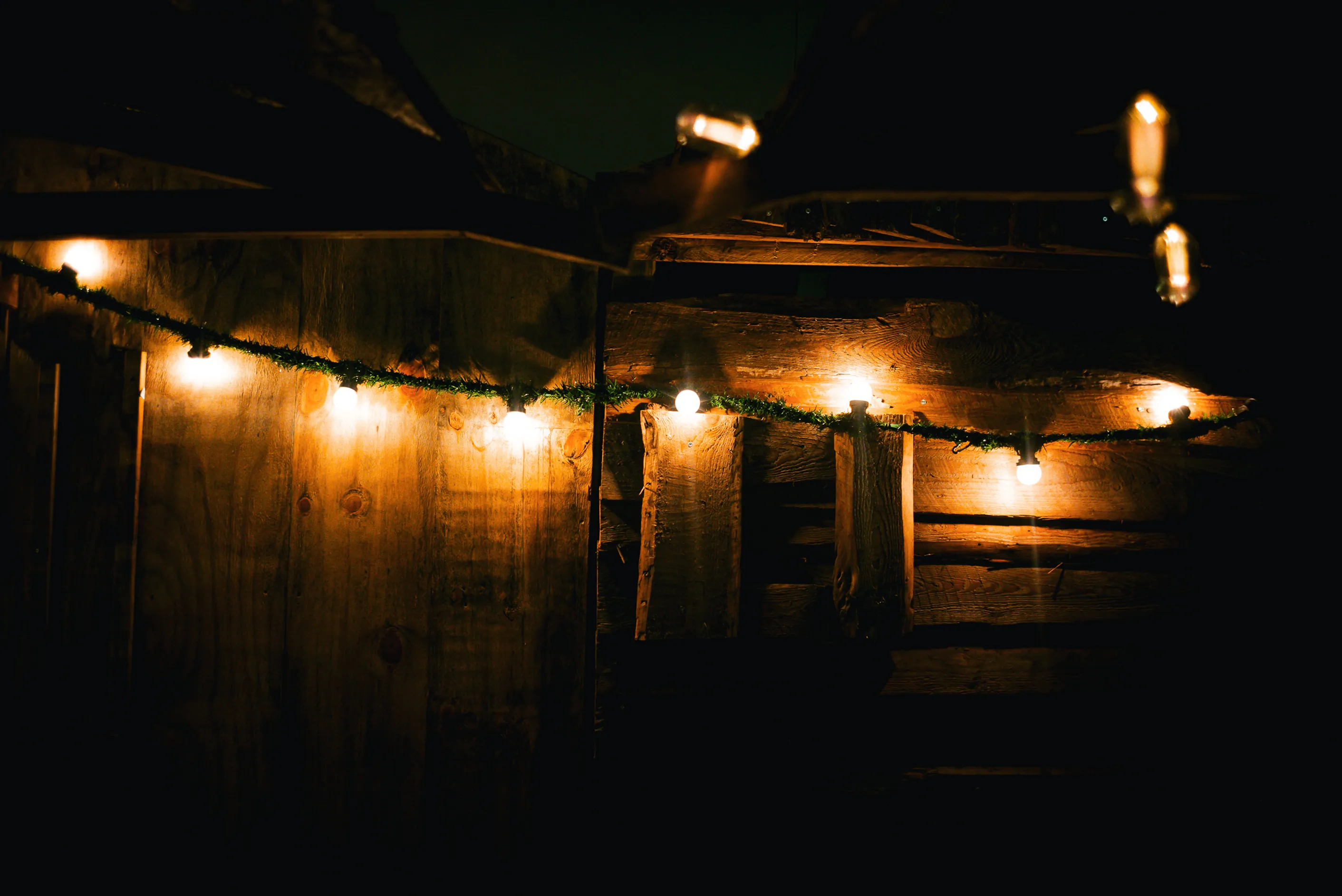 Lichterkette vor Holzwand im Findorffer Winterdorf