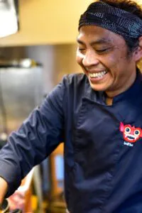 Lächelnder Inhaber beim Kochen.