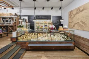 Inhaberin des Käsekontors hinter ihrer Käsetheke im Laden