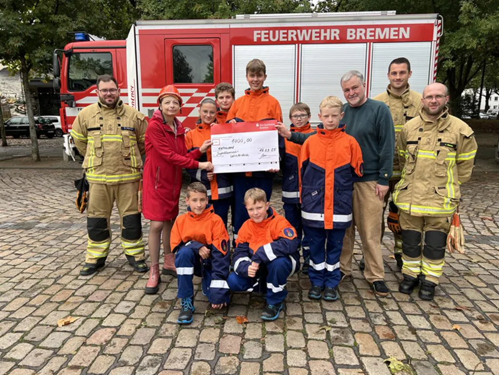 Symbolische Spendenübergabe die Jugendfeuerwehr vor dem Einsatzwagen