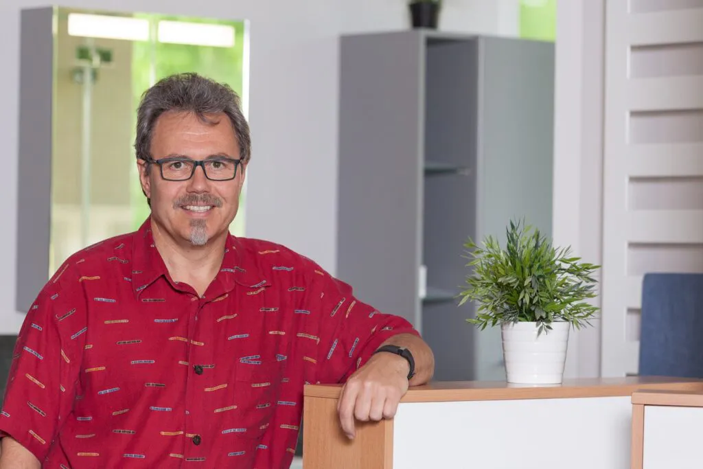 Inhaber Ralf Warnecke lehnt am Tresen in seinem Büro