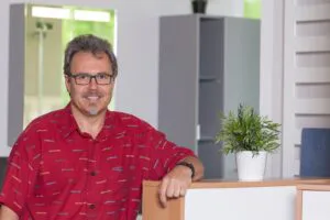 Inhaber Ralf Warnecke lehnt am Tresen in seinem Büro