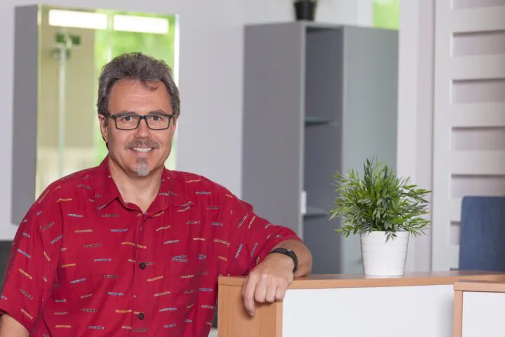 Inhaber Ralf Warnecke lehnt am Tresen in seinem Büro