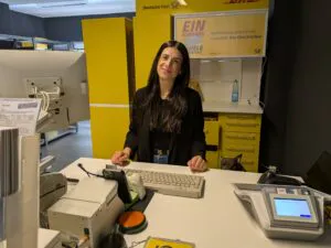 Die Inhaberin hinter dem Tresen der Deutschen Post Filiale