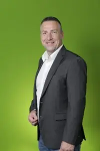 Versicherungskaufmann Marc von Bargen vor einer grünen Wand portraitiert